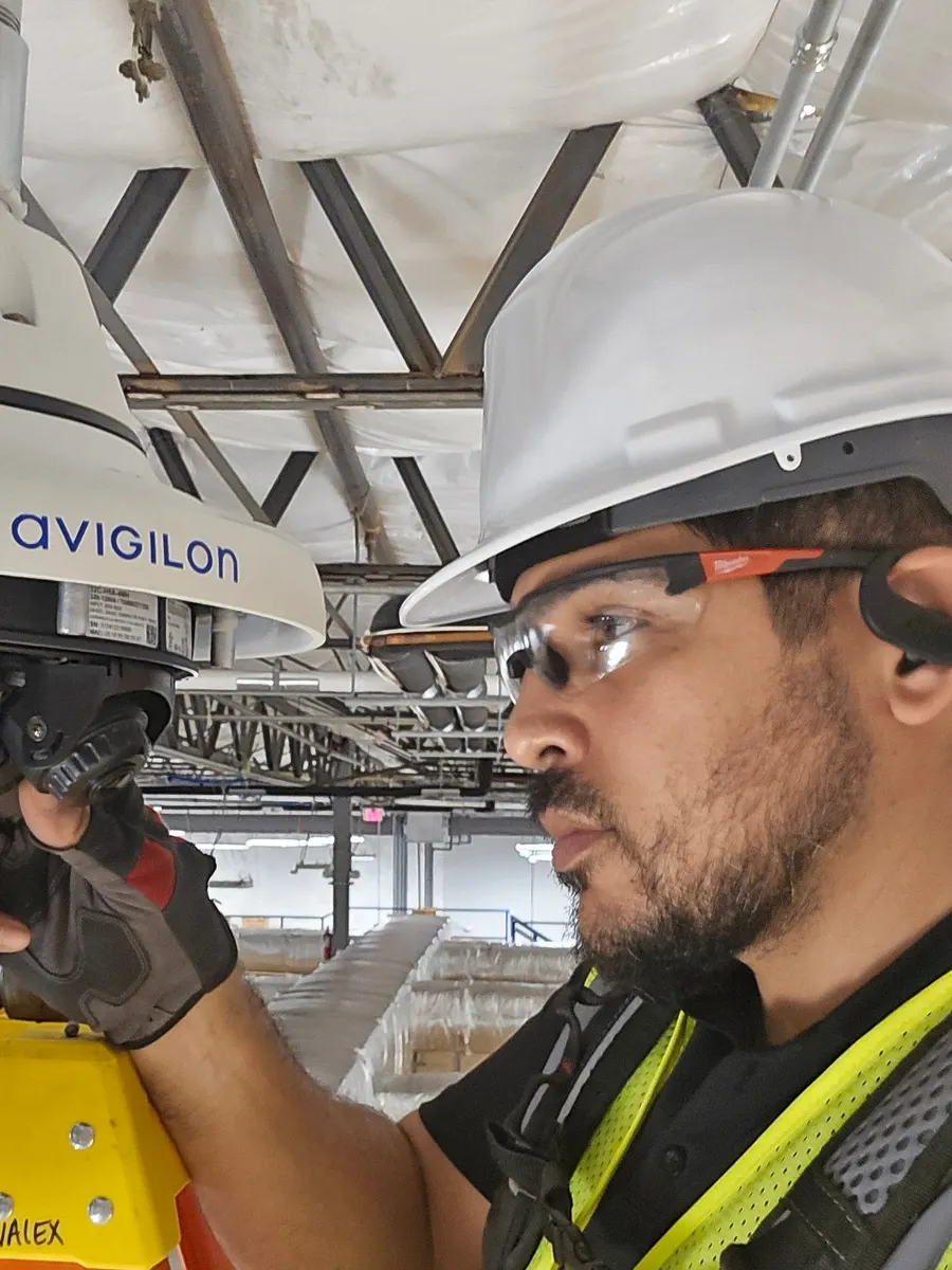 Joshua adjusting an Avigilon multi-sensor camera from a ladder