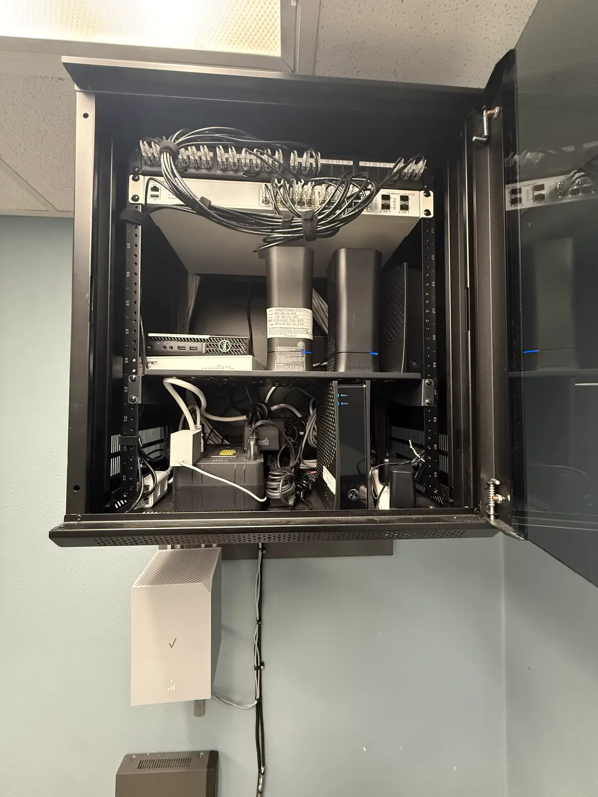 Wall-mounted network enclosure with a cellular router mounted below