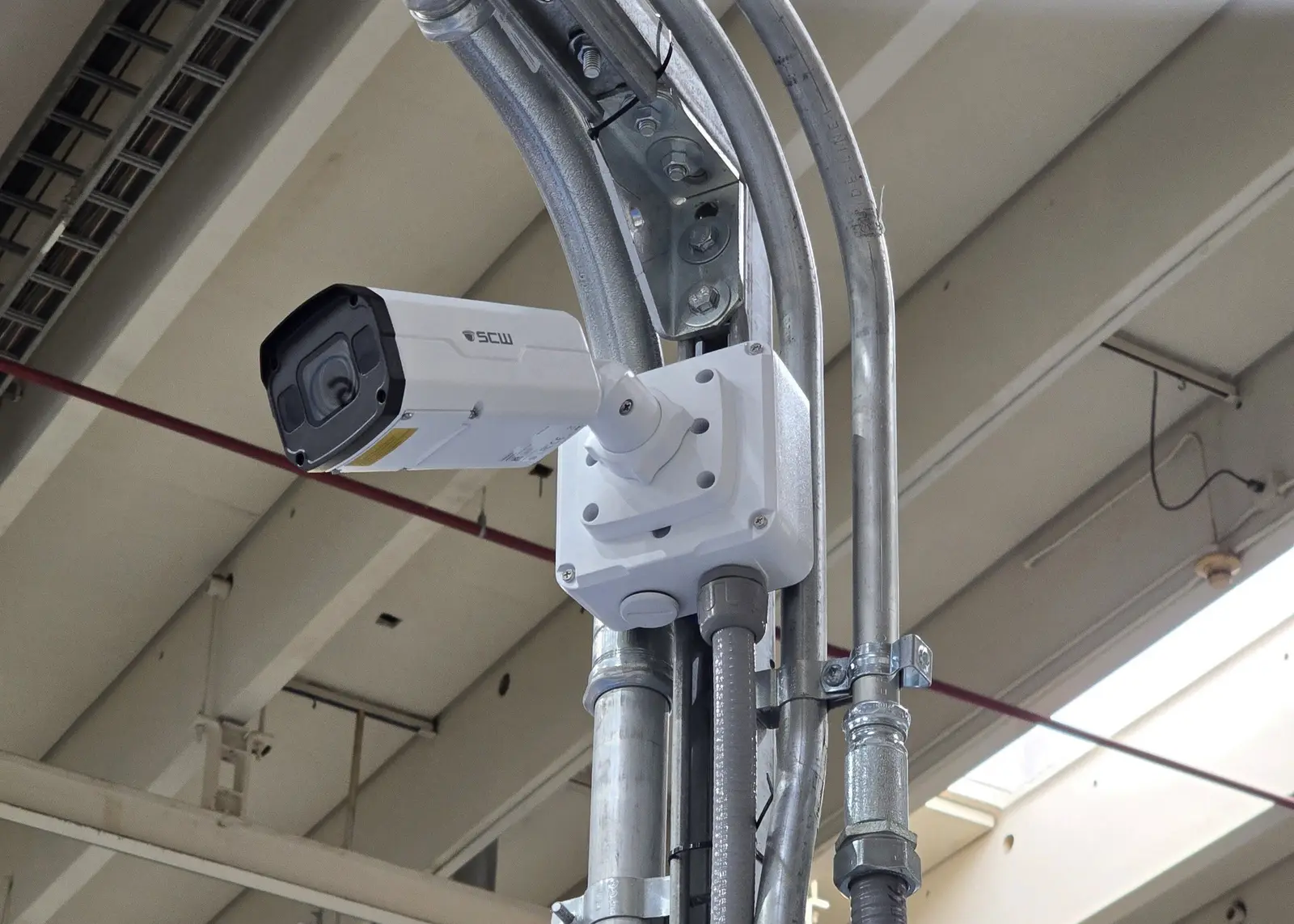 Bullet camera on a junction box mounted to overhead structure