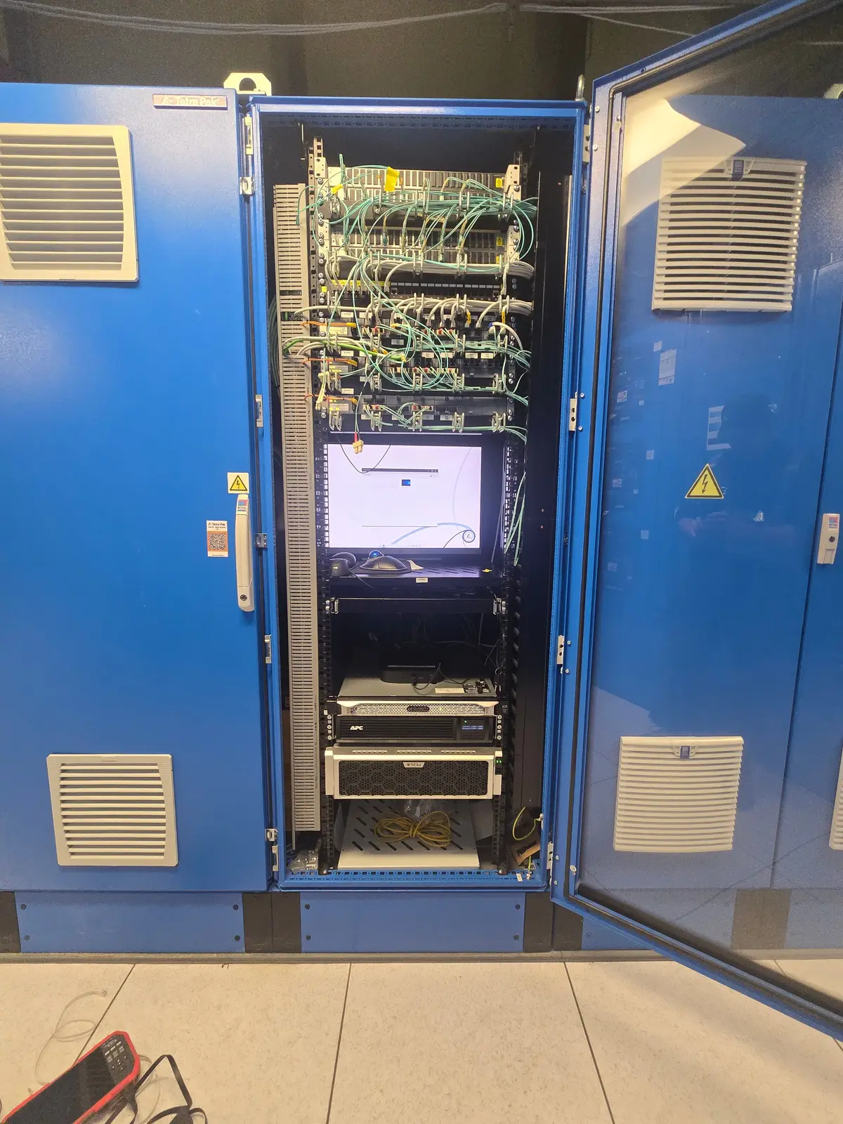 Open network cabinet with patched switches and a monitor