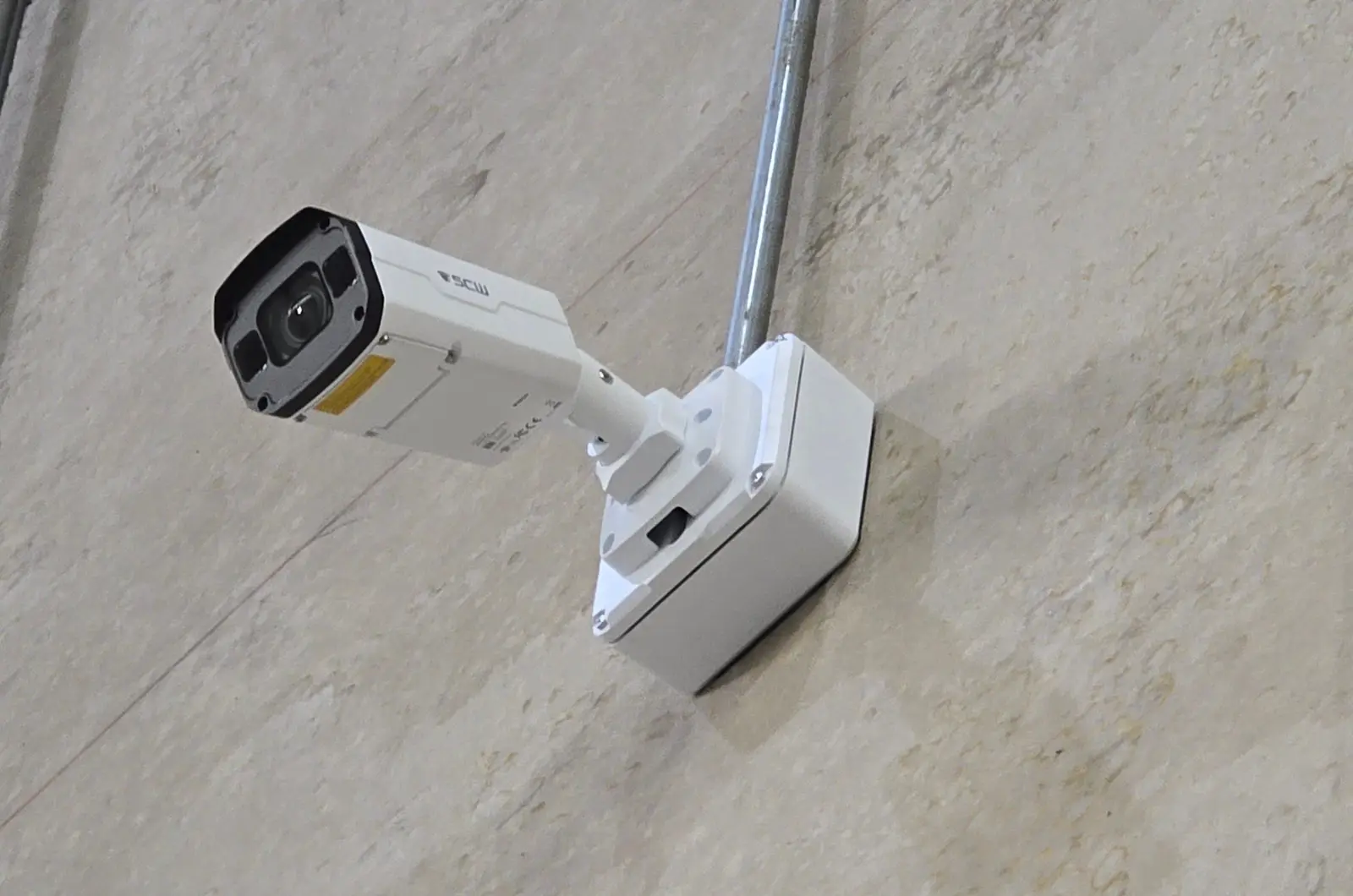 Bullet camera on a concrete wall with conduit