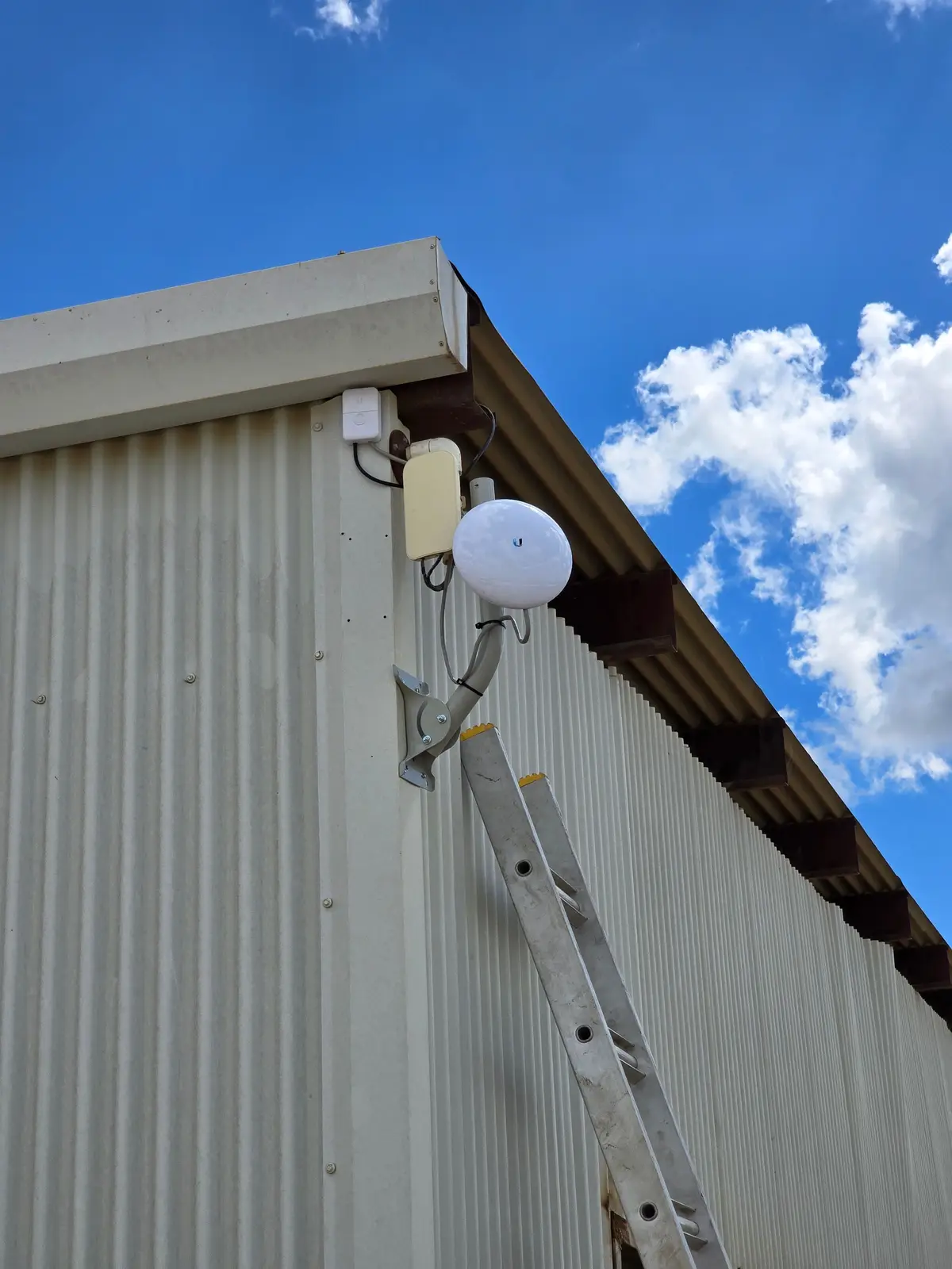 Wireless bridge and enclosure on the eave of a metal building