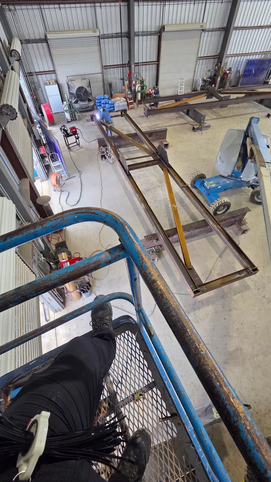 View down from a lift basket onto a steel fabrication floor